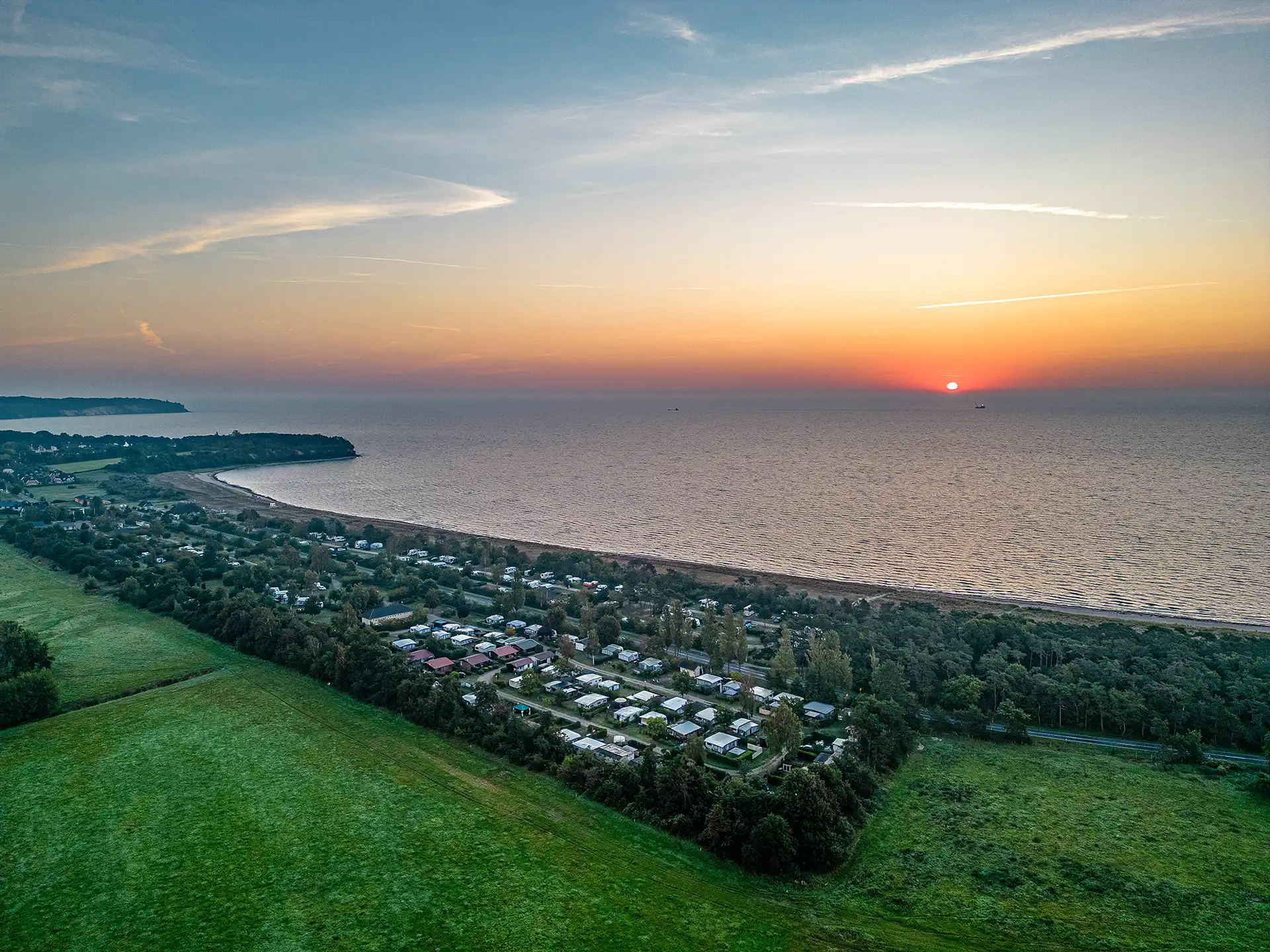 Aerial photograph of the Stranddoerp campsite with the rising sun over the sea