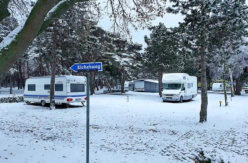 Wohnmobile auf dem schneebedeckten Campingplatz